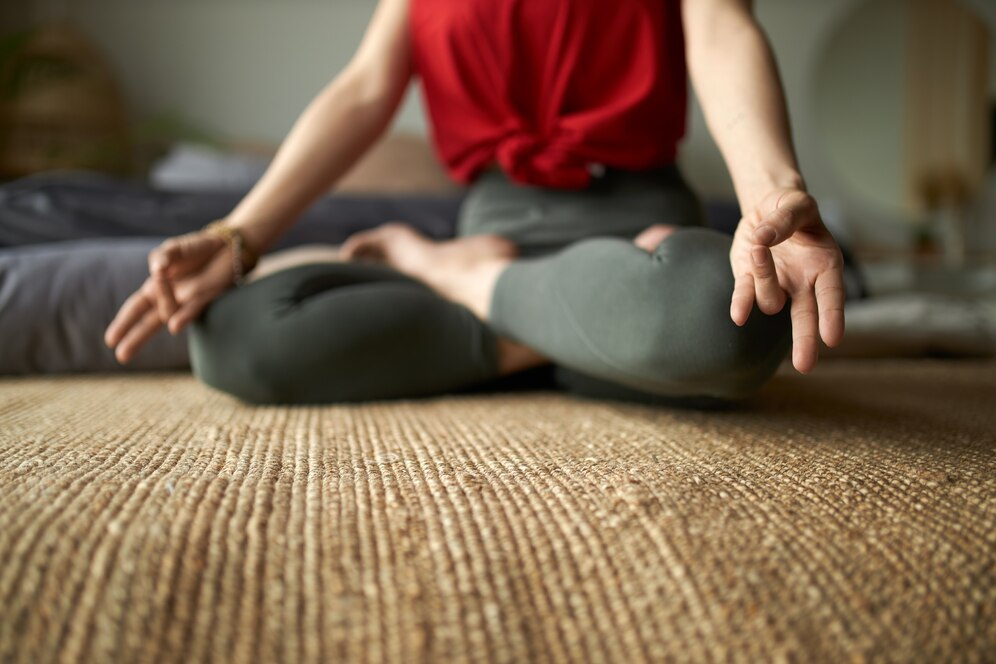 cropped-image-barefoot-woman-leggings-sitting-carpet-lotus-posture-practicing-meditation-reduce-stress-improve-focus-attention_343059-2108 — kopia